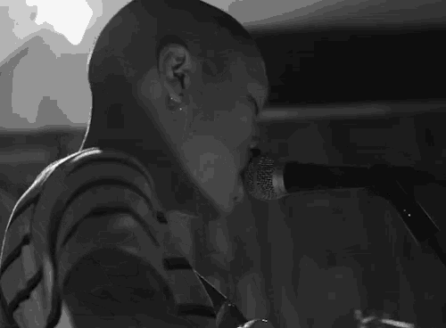 a man singing into a shure microphone with his eyes closed