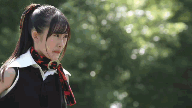 a girl with a scarf around her neck looks to her left