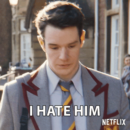 a man in a suit and tie is saying " i hate him "