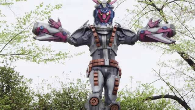 a statue of a robot is surrounded by trees on a cloudy day