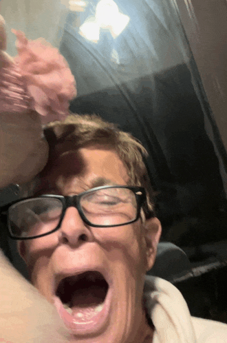 a man wearing glasses is making a funny face with his mouth open