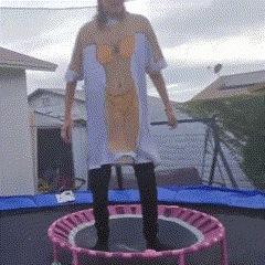 a woman in a dress is jumping on a trampoline