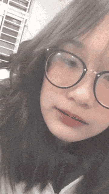a girl wearing glasses looks at the camera