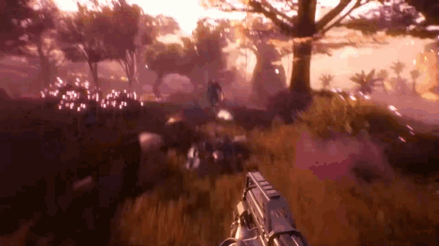 a person is holding a gun in a video game while walking through a forest .