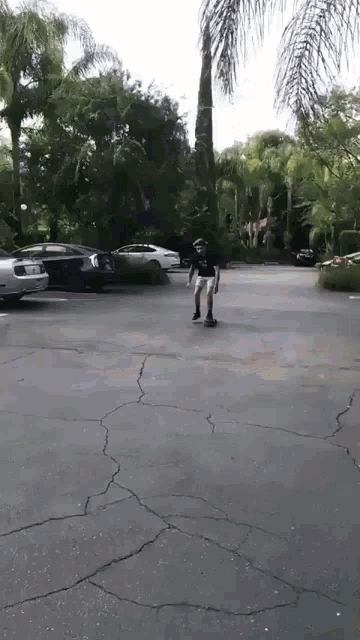 a person riding a skateboard in a parking lot with trees in the background