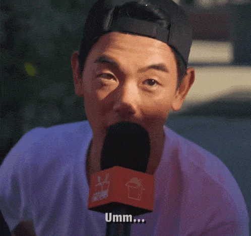 a man is talking into a microphone with the word umm written on it