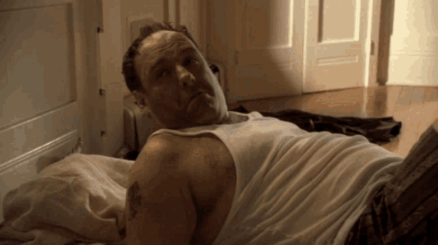 a man with a tattoo on his arm is laying on the floor