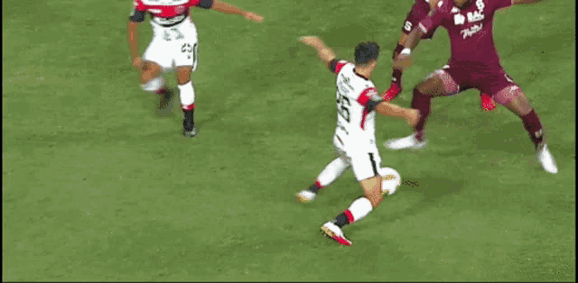 a soccer player with the number 26 on his jersey kicking the ball