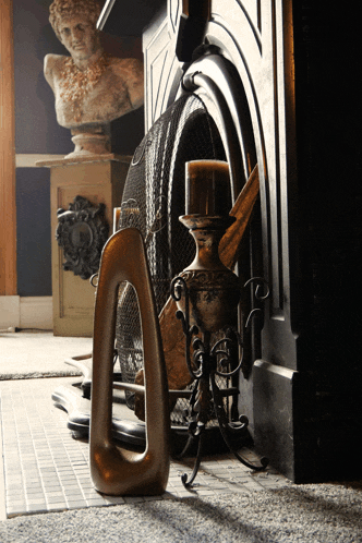 a fireplace with a statue on the mantle and a candle in it
