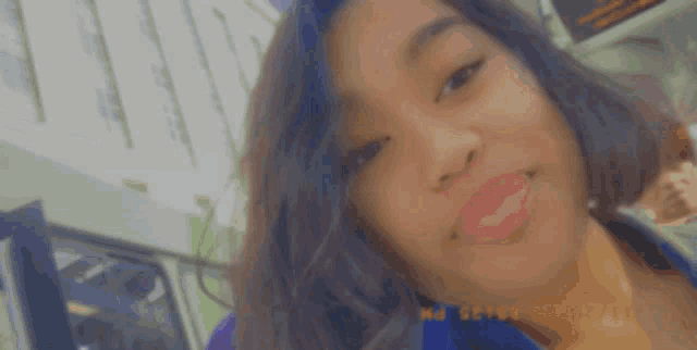 a close up of a woman 's face with a blurry background that says ' selfie ' at the bottom