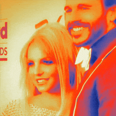 a man and woman are smiling in front of a sign that says awards