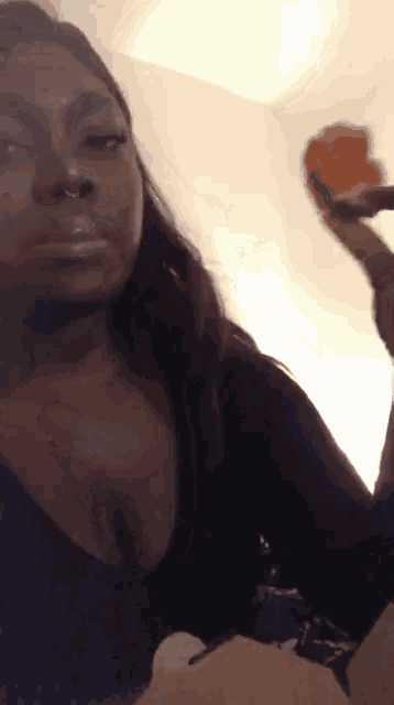 a woman with a nose ring is holding a piece of food