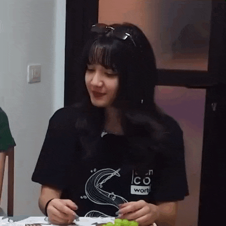 a woman is sitting at a table with a plate of food in front of her .