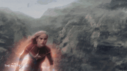 a woman in a superhero costume is flying through the air while holding a lightning bolt .