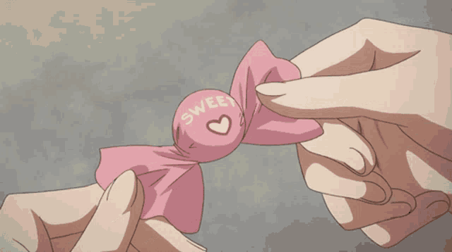 a person is holding a piece of pink paper with a red heart in the middle