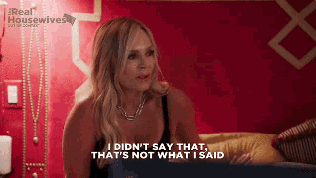 a woman is sitting on a bed and saying i did n't say that that 's not what i said .