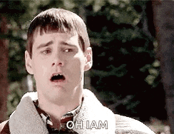 a man with a surprised look on his face is standing in front of trees .