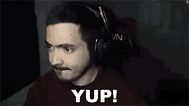 a man is wearing headphones and making a funny face .