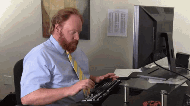 a man with a beard is typing on a keyboard