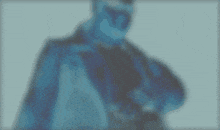 a blurry picture of a man in a suit and tie with a blue background .