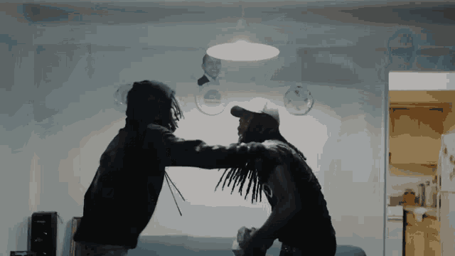 a man with dreadlocks is standing next to another man in a hoodie