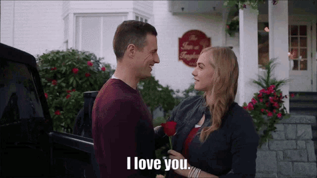 a man is giving a woman a rose and the woman is saying i love you