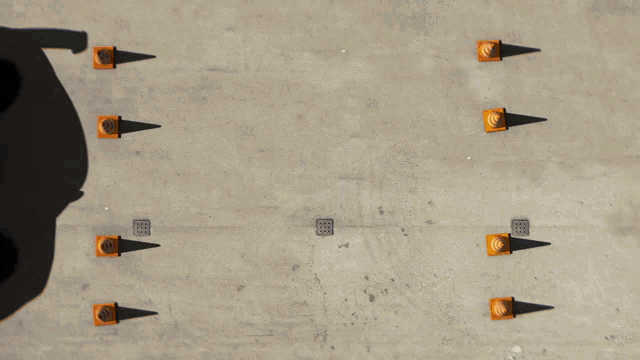 an aerial view of a car surrounded by orange cones