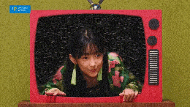 a woman is peeking out of a red television with a sticker that says upfront moving