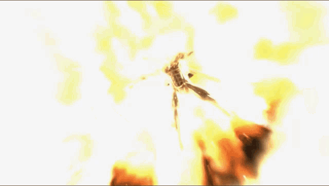 a man is standing in front of a large explosion of fire