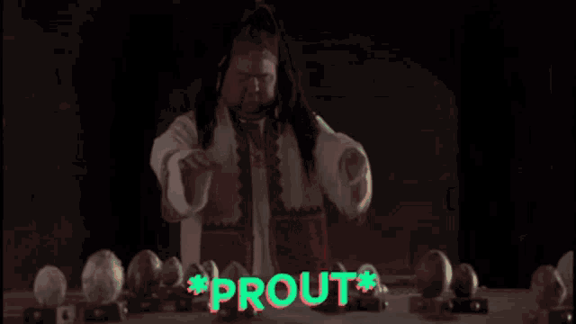 a man is sitting at a table with eggs in front of him and the word prout is visible