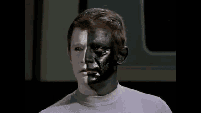 a man with half his face painted white and half black .