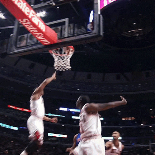 a basketball game is being played in front of a sign that says state farm