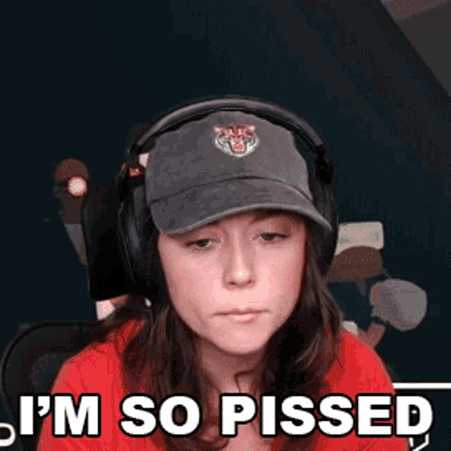 a woman wearing headphones and a hat with a tiger on it says i 'm so pissed