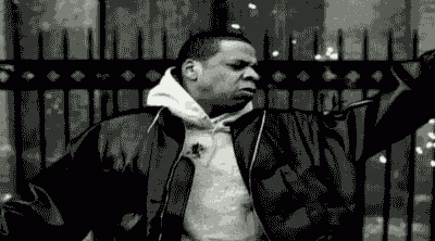 a black and white photo of a man in a leather jacket smoking a cigarette .