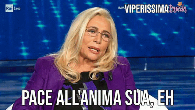 a woman wearing glasses and a purple jacket says pace all'anima sua eh