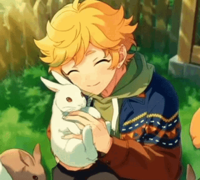 a boy is holding a white rabbit in his hands while sitting on the grass .