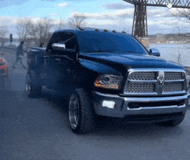 a black dodge ram truck is driving down a road