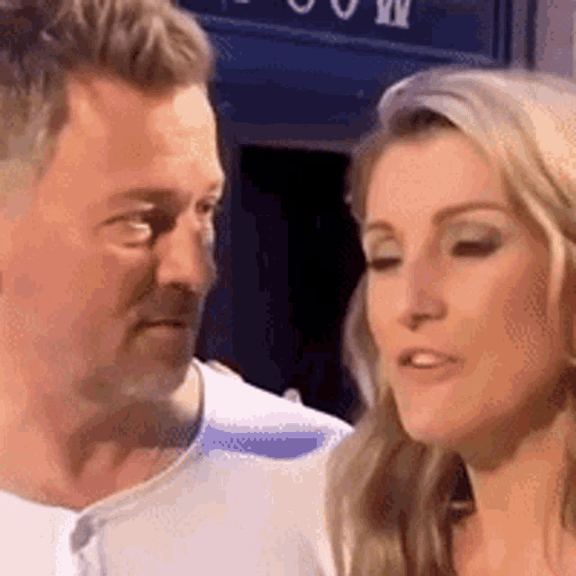 a man and a woman are standing next to each other in front of a blue door .