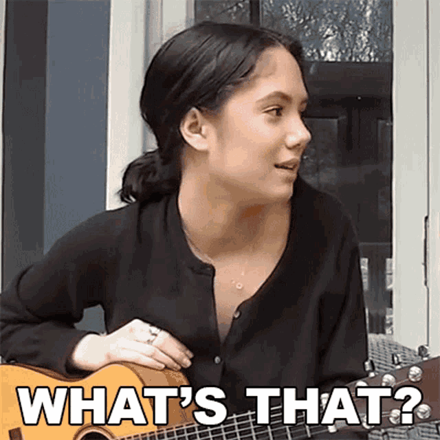 a woman is playing a guitar and says what 's that .
