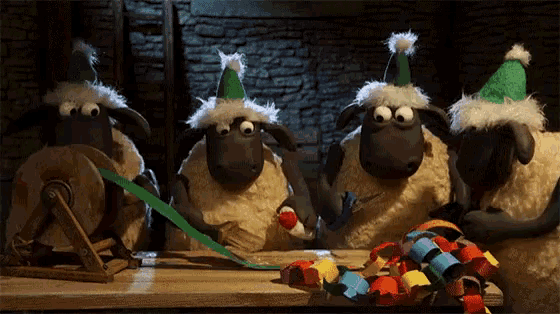 a group of sheep wearing party hats are sitting at a table