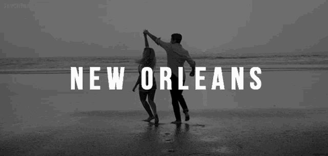 a man and a woman are dancing on a beach with the words new orleans above them