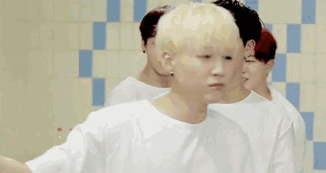 a group of young men with one wearing a white shirt with a yellow sticker that says oth