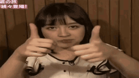 a woman is giving a thumbs up sign with her hands .