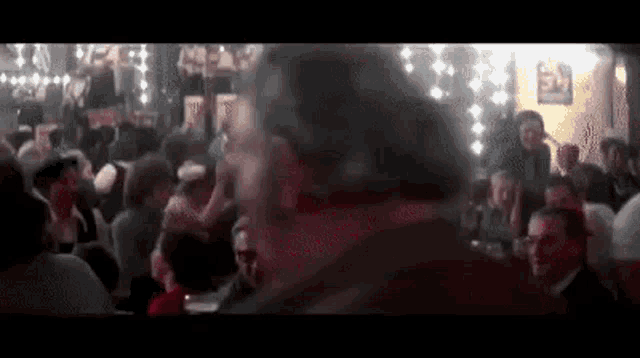 a man is standing in front of a crowd of people at a party .