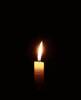a candle is lit in the dark with a blue candle sticking out of it