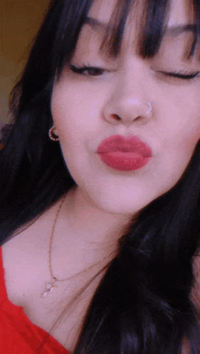 a close up of a woman 's face with her eyes closed and red lips