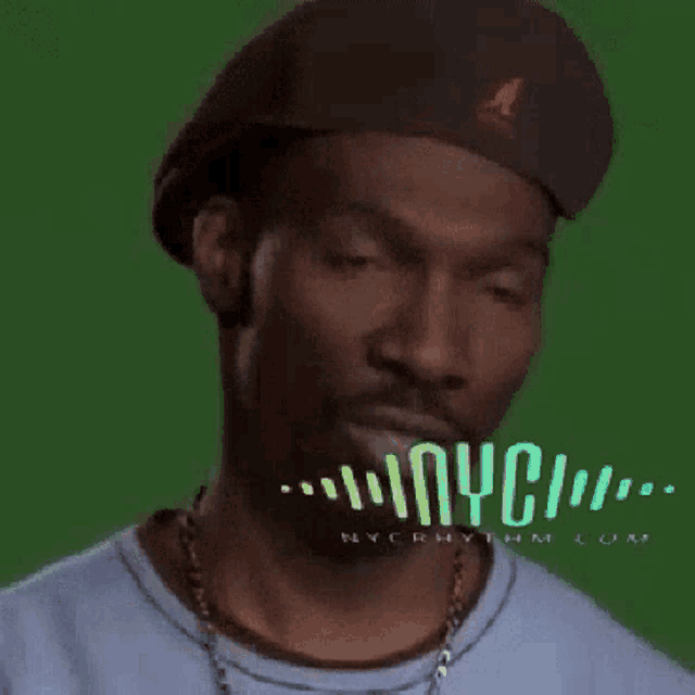 a man wearing a hat and a blue shirt with nyc written on the green background