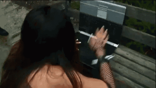a woman sitting on a bench with a laptop on her lap .