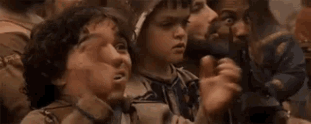 a group of people are sitting in a room with their mouths open and their hands outstretched .