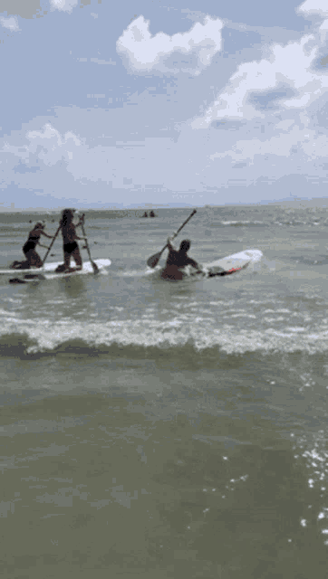 a man and a woman are paddling boards in the ocean